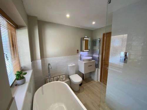 a bathroom with a tub and a toilet and a sink at 2 Regent Square in Rye