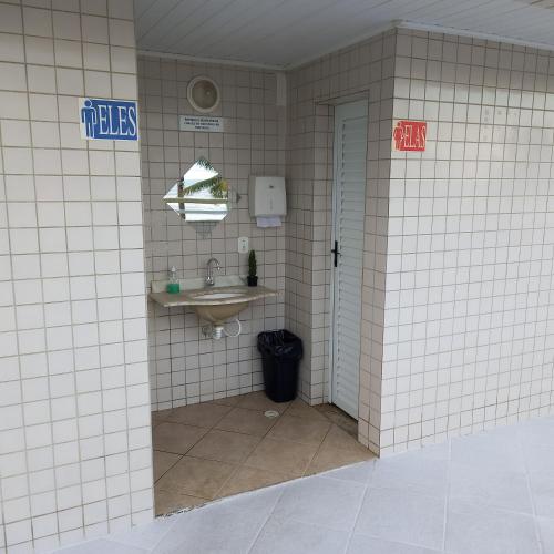 a bathroom with a sink and a toilet at Ótimo apartamento condomínio frente a praia in Mongaguá
