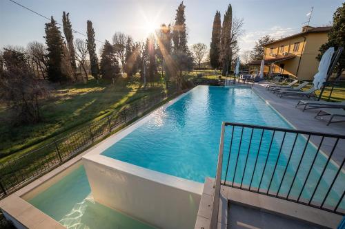 a swimming pool in a yard with chairs and trees at Residenza Paradisea in Arezzo