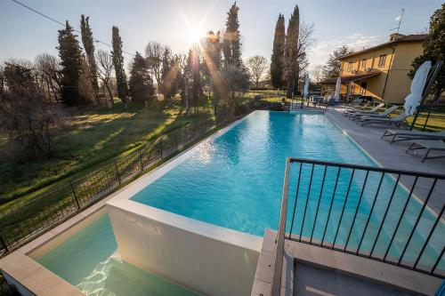 basen na dziedzińcu z krzesłami i drzewami w obiekcie Residenza Paradisea w Arezzo