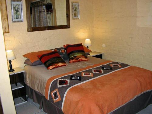 a bedroom with a large bed with two tables and two lamps at Little Lotta Cottage in Caledon