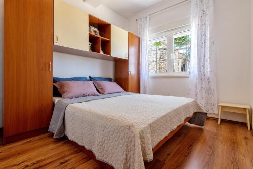 1 dormitorio con cama y ventana en Apartments Leona, en Neum