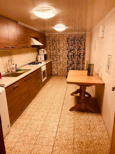 a kitchen with a wooden table and a tableasteryasteryasteryasteryasteryasteryastery at Дом - дача in Chornomorsk