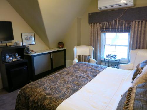 a hotel room with a bed and a window at The Woodview Inn in Gananoque