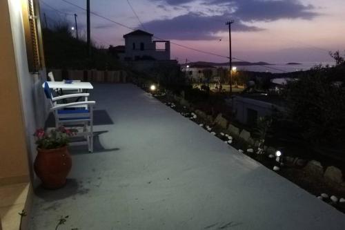 - une terrasse avec une table et un banc dans un bâtiment dans l'établissement LORENTZIA ROOM, à Batsi