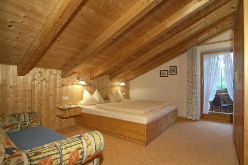 een slaapkamer met een groot bed en een raam bij Landhaus Eschenbach in Schönau am Königssee