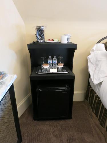 a small black table with cupcakes on it next to a bed at The Woodview Inn in Gananoque