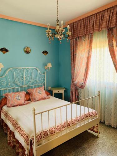 a bedroom with a bed with blue walls and a chandelier at Vivienda Vacacional FLORATERE in Arona