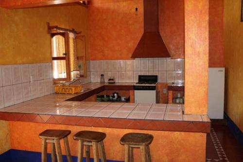 una cucina con bancone e sgabelli di Cabaña en Mazamitla - Jade a Mazamitla