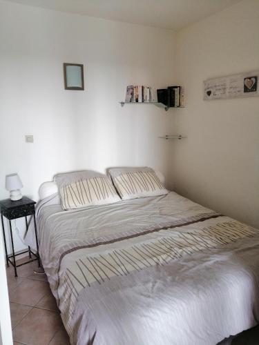 Ce lit se trouve dans une chambre blanche dotée d'un canapé-lit. dans l'établissement Petit coin de paradis, à La Croix-Valmer