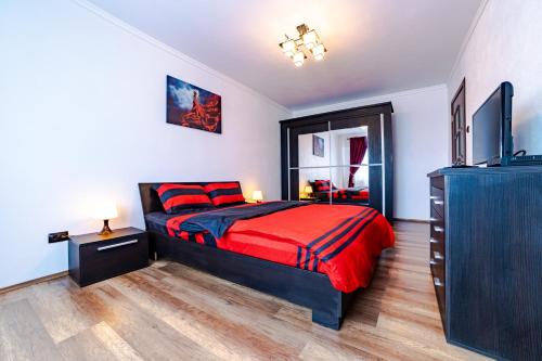 um quarto com uma cama, uma cómoda e uma televisão em Apartament Garii em Braşov