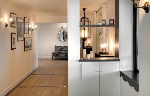 a hallway with white cabinets and a living room at Hôtel & Spa Les Mouettes in Argelès-sur-Mer