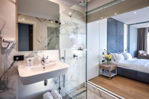 a bathroom with a sink and a shower at Yacht Hotel in Vlorë