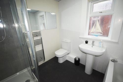 a bathroom with a toilet and a sink and a shower at The Retreat in Blackpool