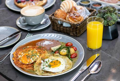 a table with a plate of breakfast food and juice at Hyatt Regency Andares Guadalajara in Guadalajara