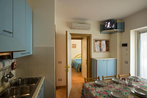 uma cozinha com uma mesa e um quarto com uma cama em Appartamenti Mimi em Lido di Jesolo