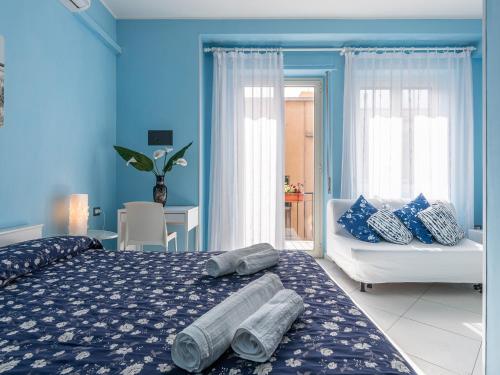 a blue bedroom with a bed and a chair at Thanit Rooms in Cagliari