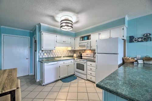 a kitchen with white appliances and blue walls at Beachfront Condo with Boardwalk and Pool Access! in Atlantic Beach