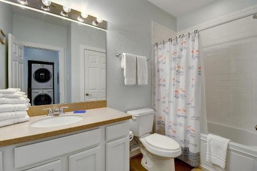 a bathroom with a toilet sink and a shower curtain at I am So Swamped in Port Aransas