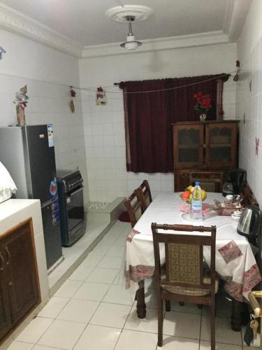 a kitchen with a table and a kitchen with a refrigerator at Chez Jamila in Dakar