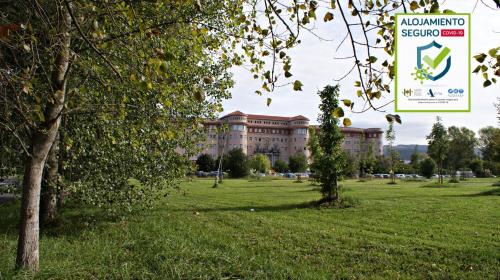 a building in a park with a grassy field at Hotel Seminario Aeropuerto Bilbao in Derio