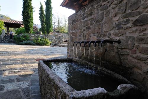 a stone water fountain in a stone wall at Fattoria Casamora - Suites in Pian di Scò