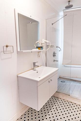 a white bathroom with a sink and a shower at Galata Door Hotel in Istanbul