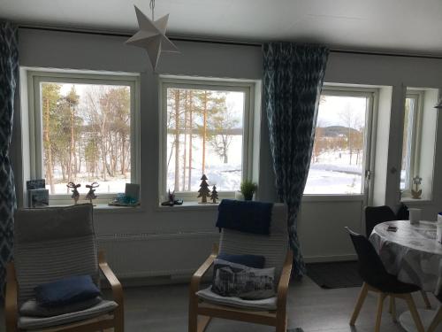 ein Esszimmer mit einem Tisch und 2 Fenstern in der Unterkunft SINITALO in Inari