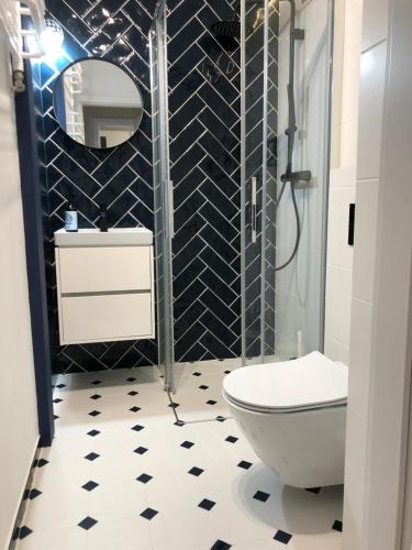 - une salle de bains en noir et blanc avec toilettes et lavabo dans l'établissement Apartament Blisko Morza i Parku Gdańsk Brzeźno, à Gdańsk