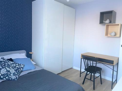 a bedroom with a bed and a desk with a chair at Apartament Blisko Morza i Parku Gdańsk Brzeźno in Gdańsk