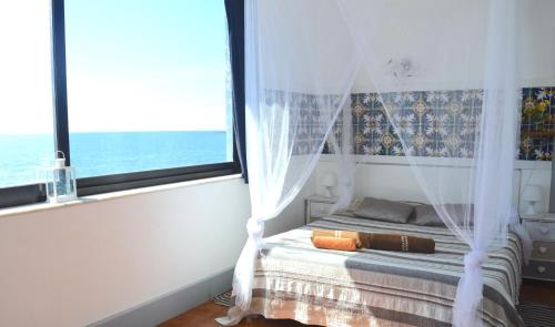 a bedroom with a bed with a window at Appartamento Teocle beach in Giardini Naxos