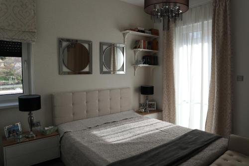 ein Schlafzimmer mit einem großen Bett und einem Fenster in der Unterkunft Fűzi-Lizi Apartman in Balatonfůzfő