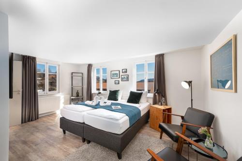 - une chambre avec un lit et une chaise dans l'établissement Hotel das Q, à Aldingen