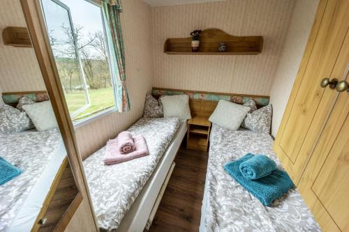 ein kleines Zimmer mit 2 Betten und Handtüchern darauf in der Unterkunft Mobilheim Atlas Villa V. - Výrovická přehrada in Znojmo