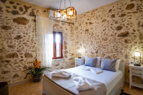 um quarto com uma cama num quarto com paredes de pedra em Villa Styliani em Kissamos