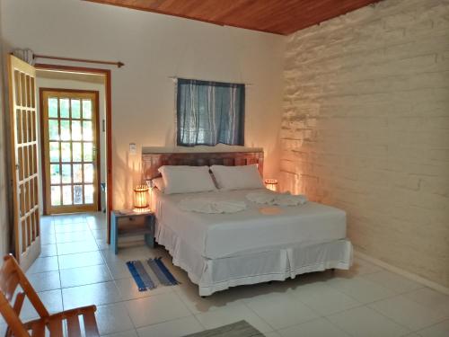 ein Schlafzimmer mit einem weißen Bett in einem Zimmer in der Unterkunft Pousada Pedras de Igatu in Igatu
