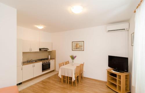 cocina y comedor con mesa y TV en Apartments Ivan, en Dubrovnik