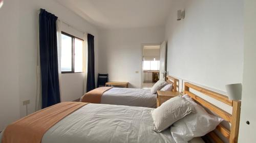 Pokój hotelowy z 2 łóżkami i lustrem w obiekcie Apt con piscina Playa Roja, La Restinga(El Hierro) w mieście La Restinga