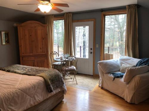 a bedroom with a bed and a couch and a table at Bed and breakfast suite at the Wooded Retreat in Pine City