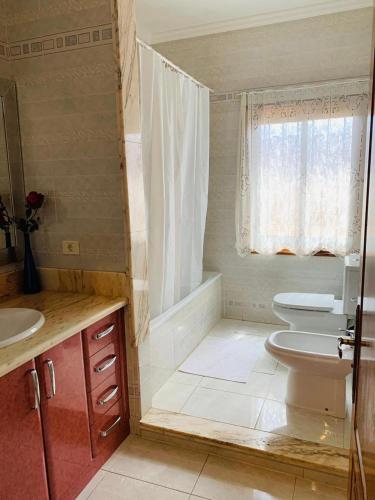 a bathroom with a sink and a toilet and a window at Vivienda Vacacional FLORATERE in Arona