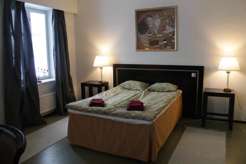 1 dormitorio con 1 cama con 2 lámparas y una ventana en Jokihovi en Nivala