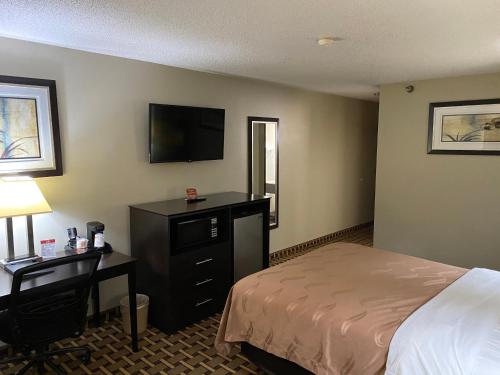 a hotel room with a bed and a desk and a television at Quality Inn Morton at I-74 in Morton
