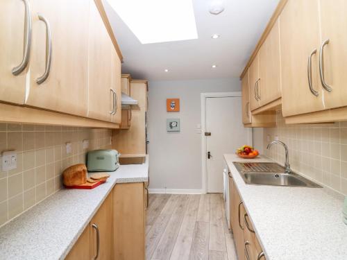 a kitchen with wooden cabinets and a sink at Gairnlea House in Ballater