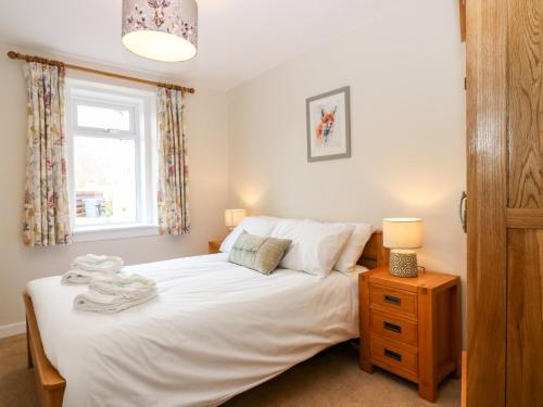 a bedroom with a bed and a window at Gairnlea Cottage in Ballater