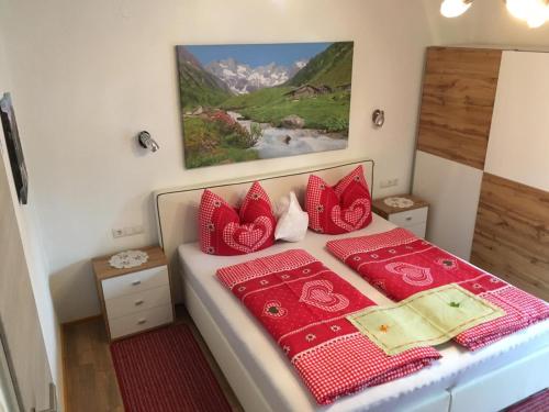 ein Schlafzimmer mit einem Bett mit roten Kissen in der Unterkunft Gästehaus Schmid in Sankt Johann im Saggautal