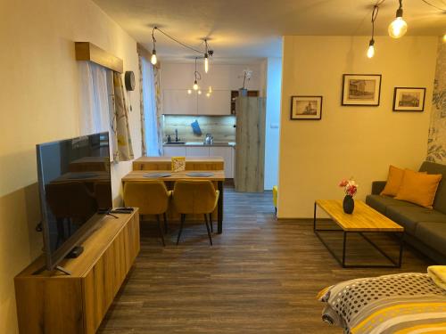 a living room with a couch and a dining room at Apartmán Champion II in Plzeň