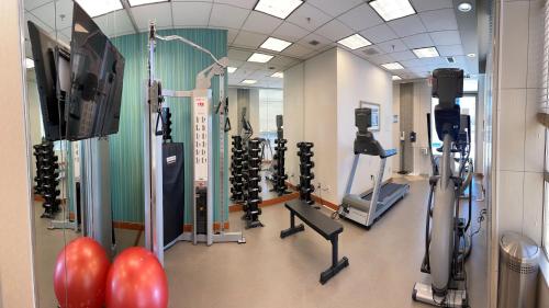 a gym with several tread machines and a television at Holiday Inn Express Vancouver-Metrotown (Burnaby) in Burnaby