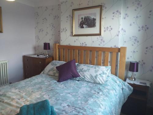 um quarto com uma cama com um edredão azul em Bank End em Egremont