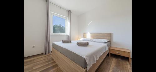sypialnia z łóżkiem i dużym oknem w obiekcie Aurum luxury apartments w mieście Vir