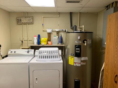 a kitchen with a refrigerator and a washing machine at Lickskillet Lodge on Fightingtown Creek; HOT TUB in Blue Ridge